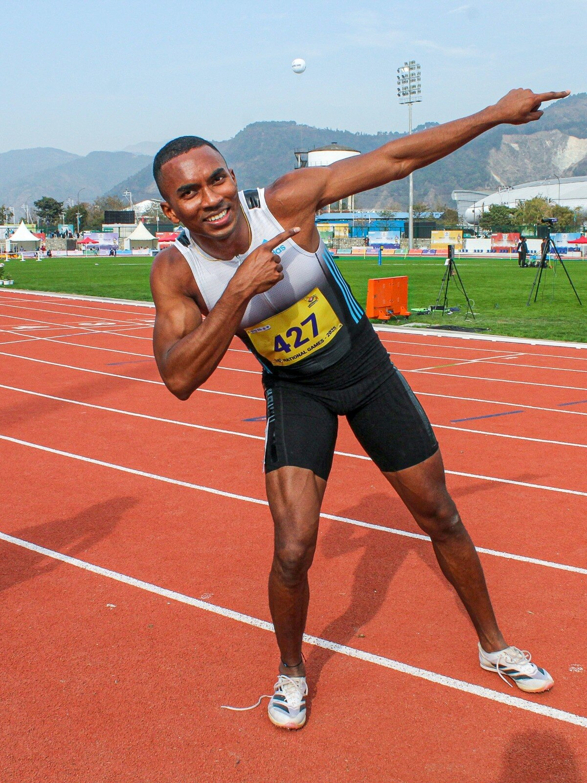 Sprinter pointing at race bib